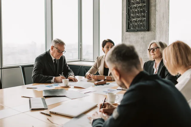 Business professionals engaged in a collaborative meeting around a conference table. Excluding prospects the business cannot serve