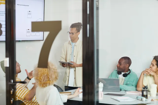 A diverse team collaborates in a modern conference room, engaging in a planning session. Outbound account prioritisation