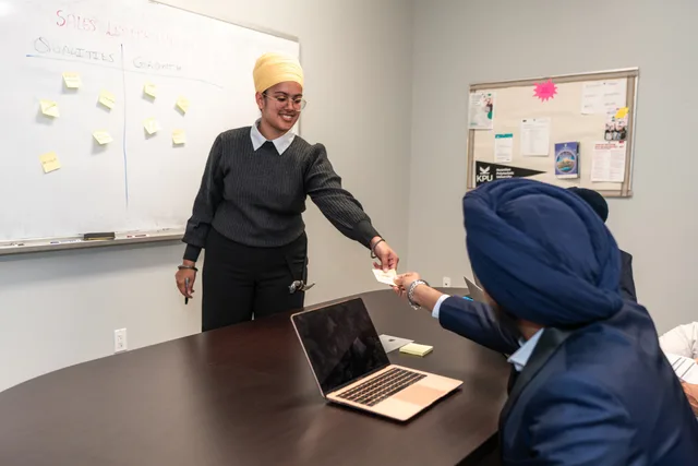 Business professionals engage in a collaborative meeting around a conference table, sharing ideas and strategies. Sales development for B2B teams