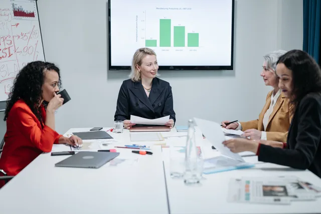 Businesswomen engaged in a productive meeting in a modern conference room with charts displayed. Sales development operations