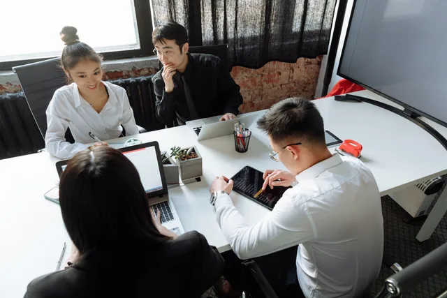 Group of diverse colleagues collaborating in a modern office environment, engaged in a meeting. SDR-to-sales handoffs